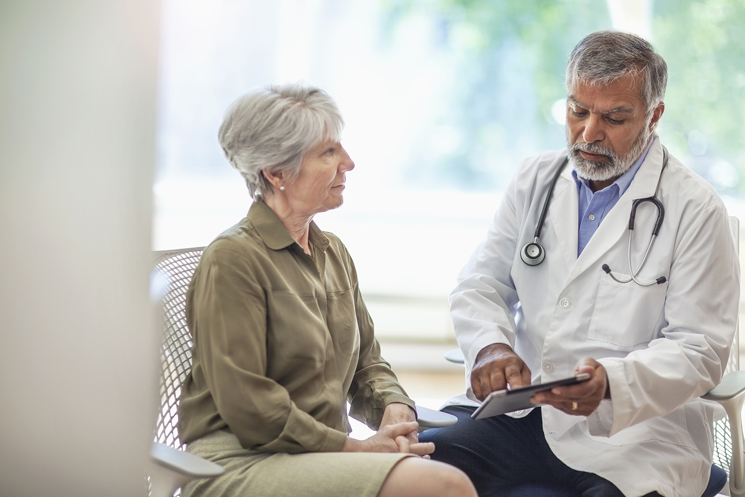 Patient visiting with doctor reviewing results on tablet