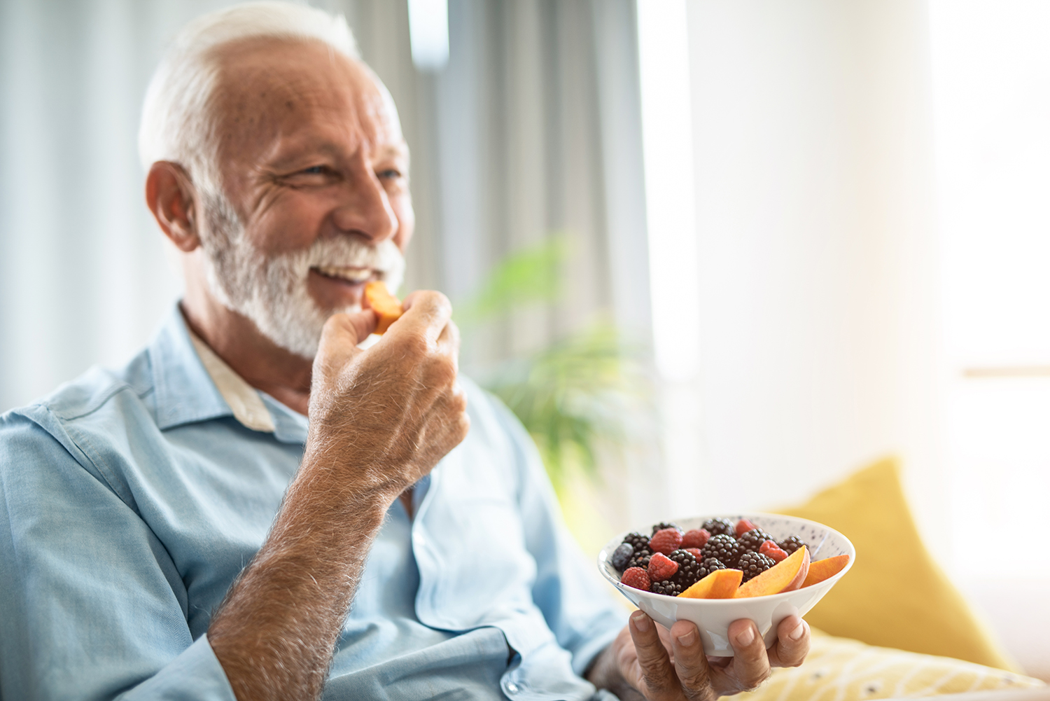 Elderly man eating bowl of fiber rich foods